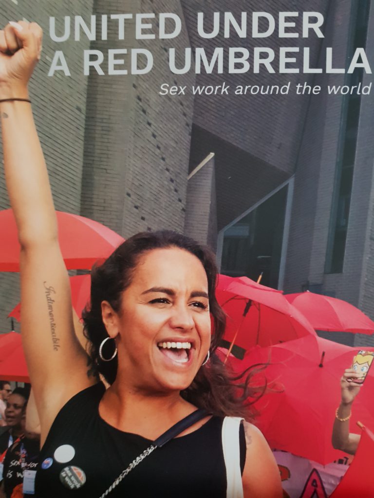 The cover with a picture of a proud Latina woman with her fist in the air and red umbrellas behind her